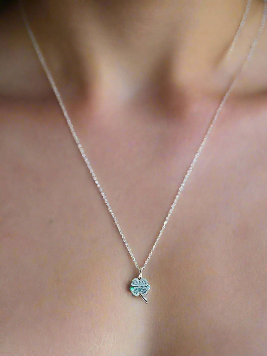 Necklace with a clover pendant on a gray stand