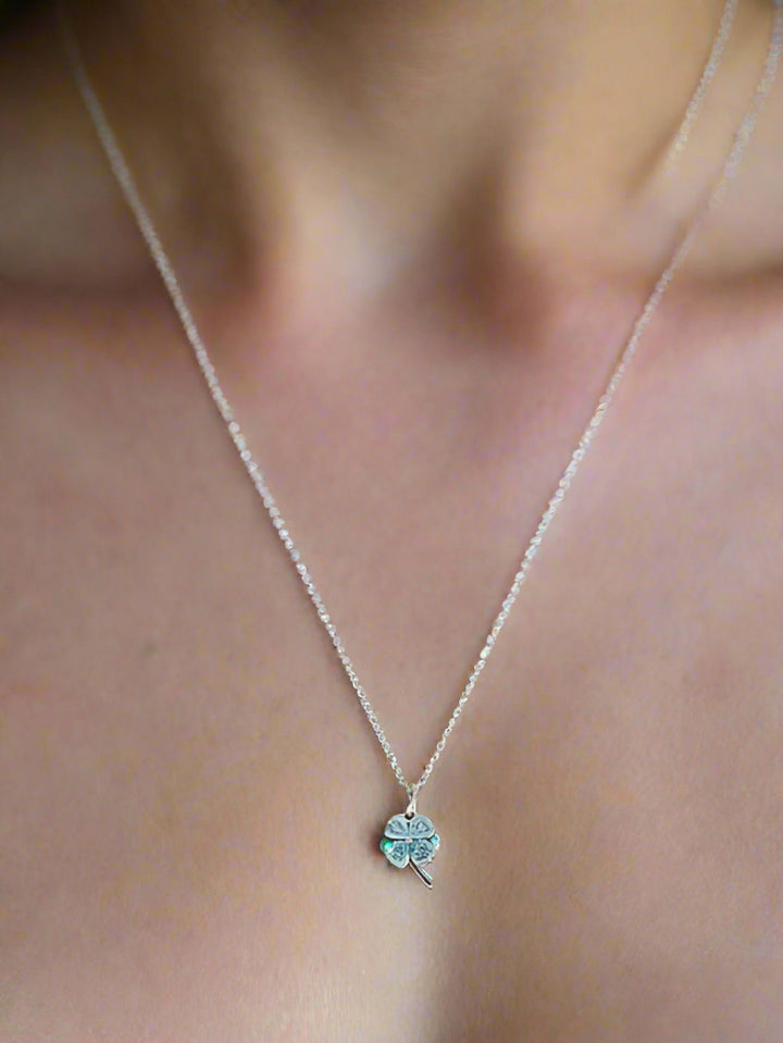Necklace with a clover pendant on a gray stand